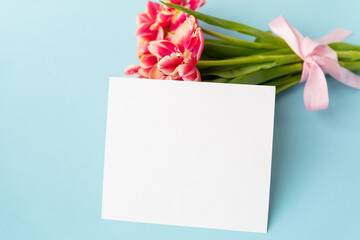 Very beautiful spring tulips on a blue paper background. Ready mokap, banner, place for an inscription.