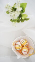 Easter setup - Easter eggs and yellow french macarons decorations on white background
