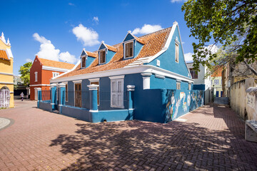 beautiful blue building with artwork on the right wall in Willemstad, Curacao