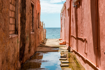 View to the Caribbean Sea through weathered red painted houses in Willemstad, Curacao