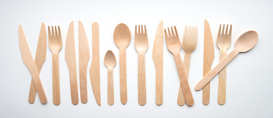 Wooden eco-friendly cutlery lies in a row, isolated