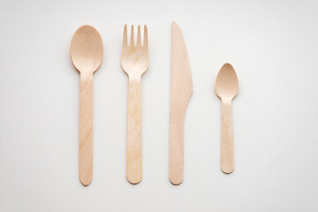 Wooden eco-friendly cutlery lies in a row, isolated