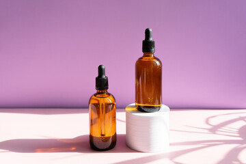 Still life of cosmetic products. Blank, isolated on a powdery pink and lilac background to accommodate your design with sun shadows.