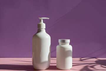 white cosmetic jars on a lilac-pink background with sun shadows. template for cosmetics.