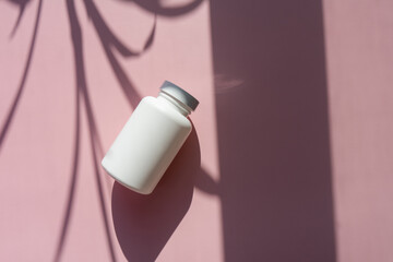
white cosmetic jars on a lilac-pink background with sun shadows. template for cosmetics. still life for a cosmetic article.