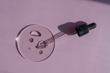 
pipette with cosmetic emulsion. composition of the use of cosmetics. pipette with serum on a transparent stand.