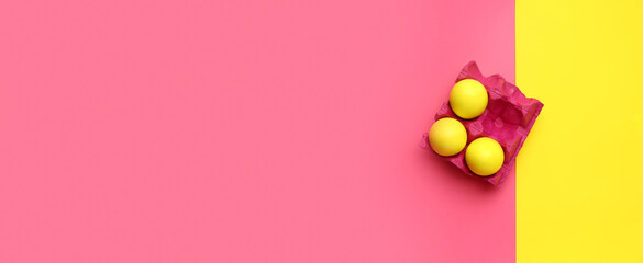 Holder with painted Easter eggs on color background with space for text