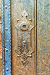 Metal decorative hinge and lock at wooden background.