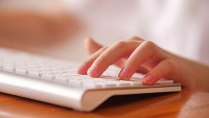 Child fingers playing action game on the white computer keyboard