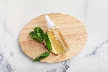 Bottle of natural mint oil on white background