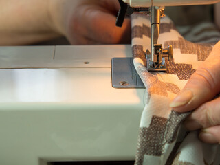 Close-up of the sewing process on a sewing machine. woman sewing curtains on a sewing machine