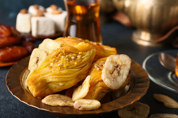Plate with tasty Turkish baklava on dark background