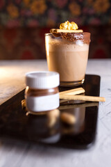 coffee on a black plate and a jar of chocolate paste