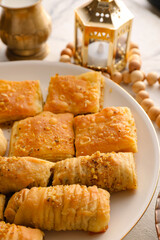 Plate with tasty Turkish baklava on table, closeup