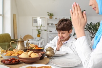 Muslim family praying together before breakfast. Celebration of Eid al-Fitr