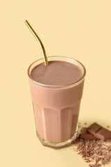 Glass of delicious chocolate milk on color background