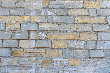 Old brick wall made of limestone stones of different sizes as a natural background