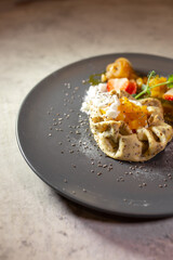 pancake with cottage cheese and fruit on a gray plate