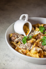 fried pasta with horse meat in a white plate
