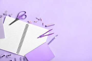 Blank notebook and stationery on purple background
