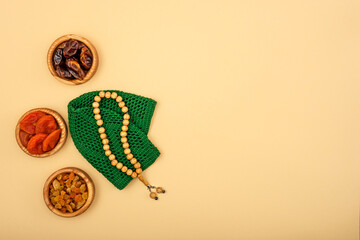 Top view of the rosary lying next to dried fruits, religious concept, love of Islam, copy space, mock up