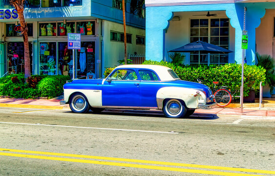 Old timer automobile painted in metallic blue and white colour parked at street in Miami Beach, USA.