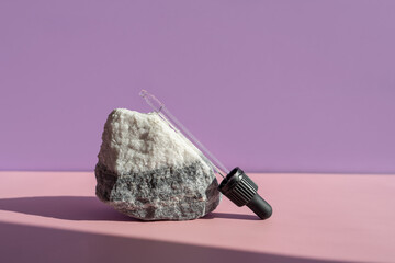 abstract composition of natural and artificial materials. natural marble stone in sunlight on a pink background.