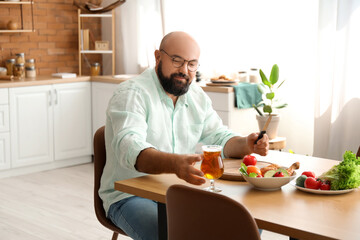 Man drinking beer while preparing lunch in kitchen