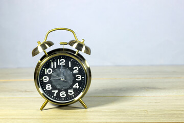 alarm clock showing twelve o'clock on  wooden table. lunch time concept