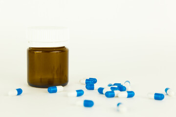 falling blue pills on pile of capsules on white background