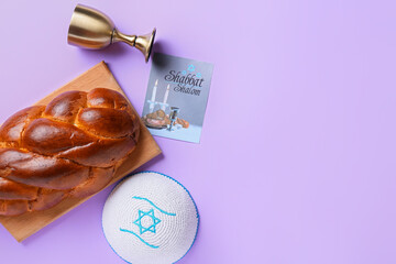 Traditional challah bread with greeting card, cup for wine and Jewish cap on color background. Shabbat Shalom - obrazy, fototapety, plakaty