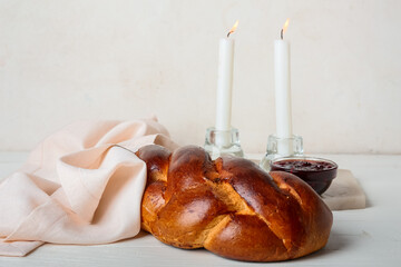 Traditional challah bread with glowing candles on white background. Shabbat Shalom - obrazy, fototapety, plakaty