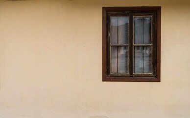 Old window on a yellow wall