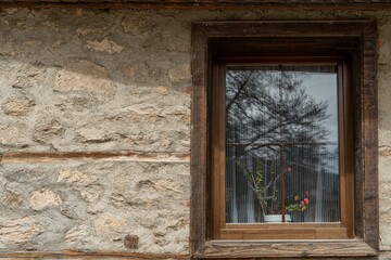 Old wooden window with a red flower