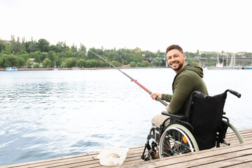 Man in wheelchair fishing on river