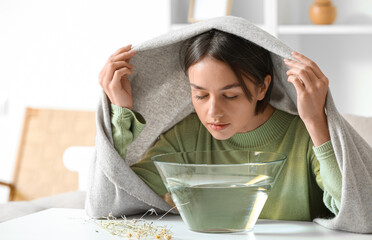 Young woman doing steam inhalation at home to soothe and open nasal passages - obrazy, fototapety, plakaty