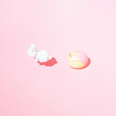 White Easter bunny jumping out of egg.Pastel colours.