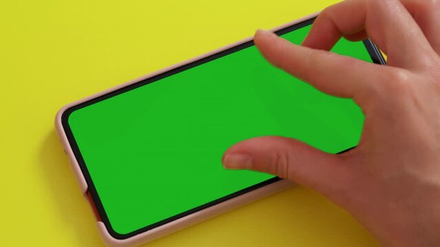 Gestures pack on Green Mock-up Screen Chroma Key phone. Female hand touching, zoom in, sliding, swiping, scrolling on smartphone screen in orizontal mode. Internet, communications concept.