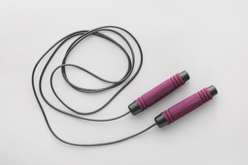 Stylish skipping rope on light background
