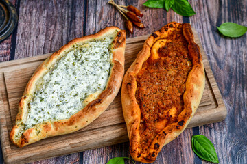  Traditional Turkish cuisine. Baked Pide dish with  cheese and  herbs on  wooden background. ...