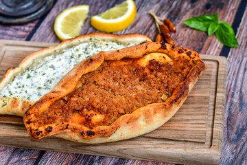  Traditional Turkish cuisine. Baked Pide dish with  cheese and  herbs on  wooden background.  Turkish pizza pide