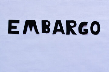 Fototapeta na wymiar Top view of embargo lettering on white background.