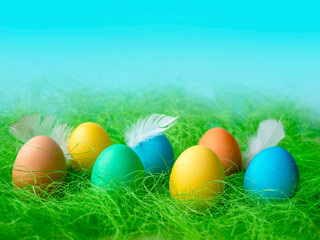 Happy Easter. A row of decorative multicolored Easter eggs on the green grass. Place for text