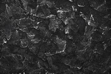 Black plaster background. Black stucco texture. Top view. Flat lay.