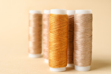 Beige sewing thread spools on light background