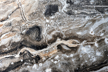 Texture of natural gray-black quartz stone with beige mineral inclusions.