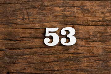 Number 53 in wood, isolated on rustic background
