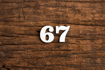 Number 67 in wood, isolated on rustic background