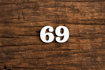 Number 69 in wood, isolated on rustic background