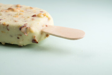 Pistachio ice cream with pistachio bits on blue background 